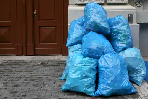 A waste skip placed on a Pinner street with local buildings in the background.